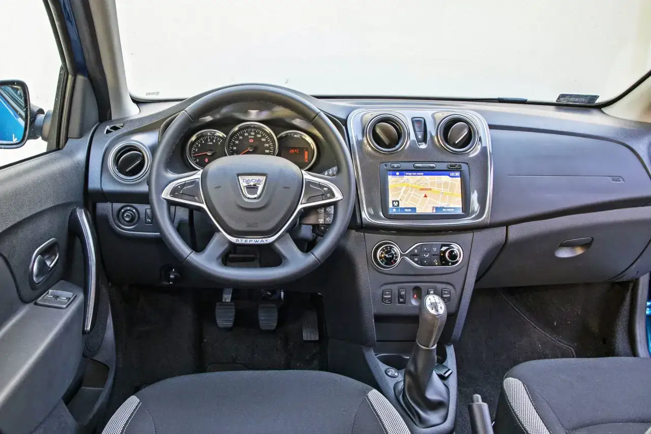 Wnętrze Dacia Sandero 2025: kierownica, nawigacja, zegary i dźwignia zmiany biegów.