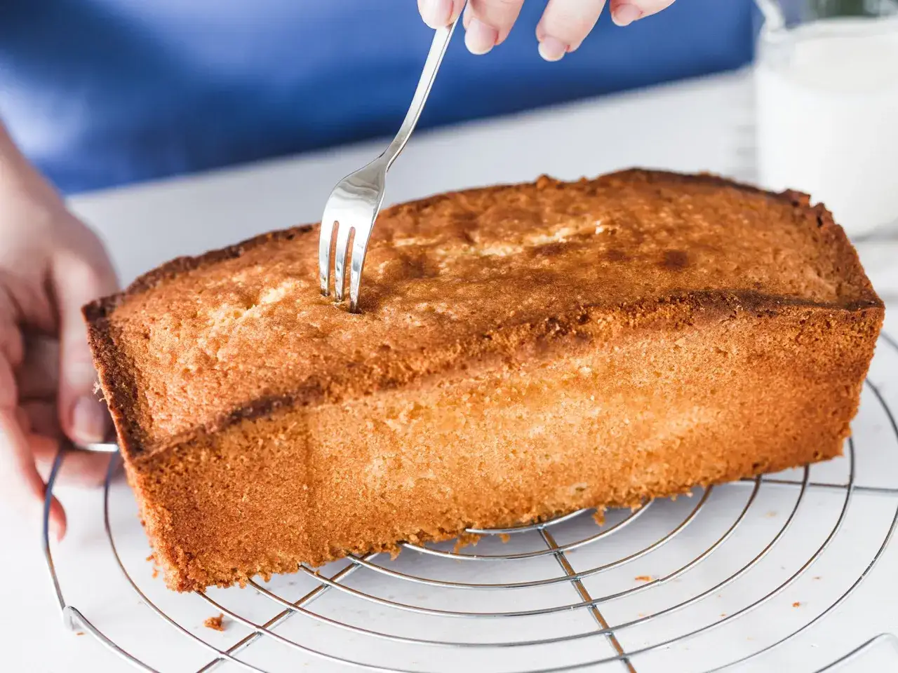 Frische Zitronenkuchen Kastenform wird mit einer Gabel getestet, ob er durch ist.