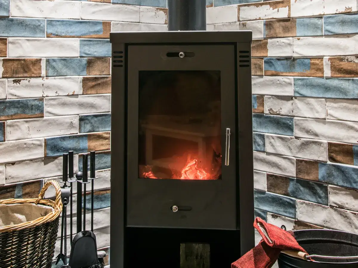 En stilig kamin med gl&ouml;dande ved ger v&auml;rme och mys. T&auml;nk p&aring; energiv&auml;rde ved f&ouml;r en effektiv eldning.