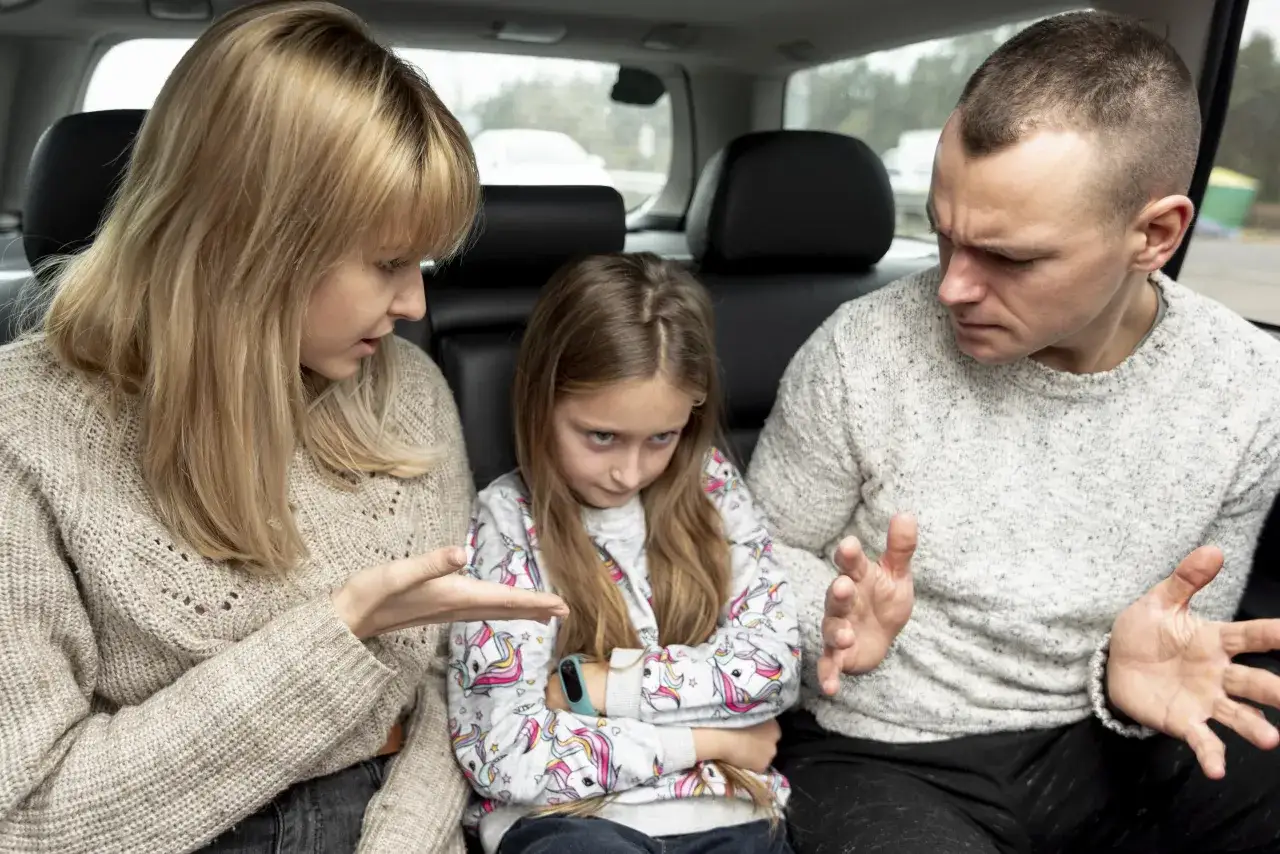 Rodzice rozmawiają z córką w samochodzie. To trudne momenty w parenting, gdy trzeba tłumaczyć.