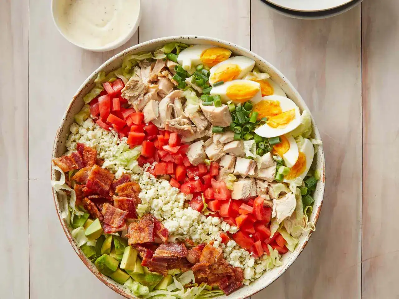 En stor cobb salad med kyckling, bacon, ägg, tomat, avokado och blåmögelost. Serveras med en krämig dressing.