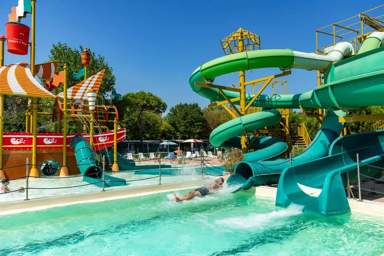Scivoli acquatici colorati e divertenti, perfetti per i campeggi in Emilia Romagna per bambini. Un uomo scende a tutta velocit&agrave;!