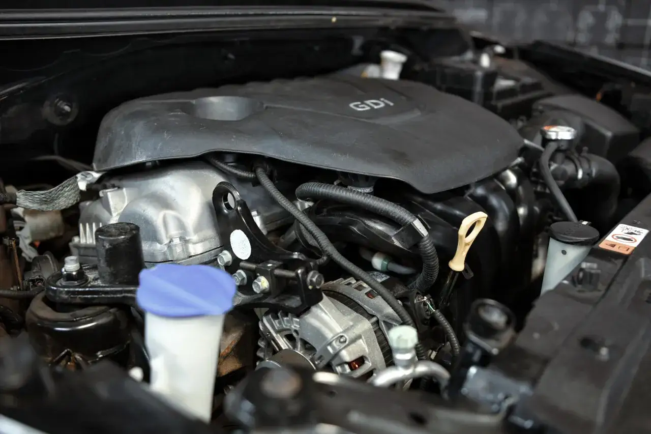 Silnik GDI w Kia Ceed 1.6 benzyna. Widoczny alternator, kolektor dolotowy i płyn chłodniczy.