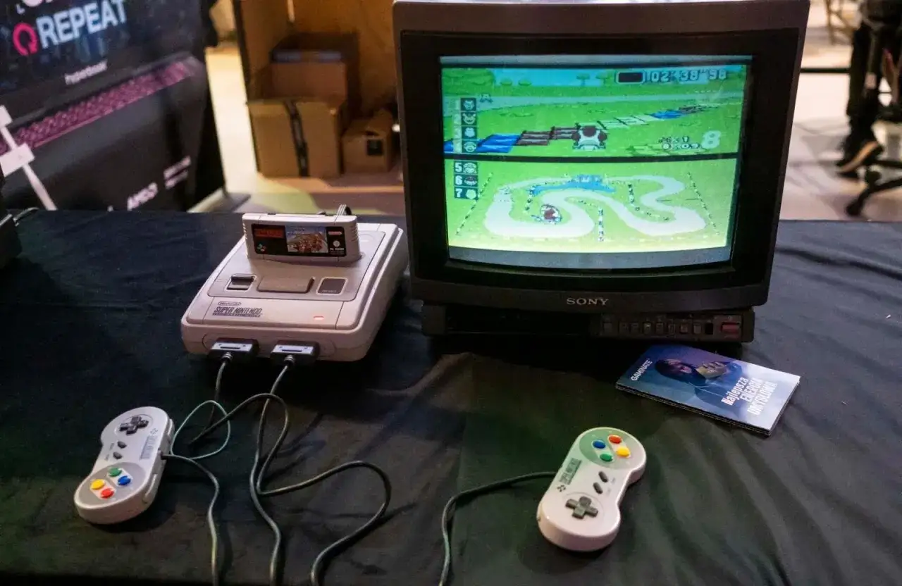 Konsola Super Nintendo z grą na ekranie, dwa kontrolery i ulotka. Klasyka retro, jakby z czas&oacute;w valve steam machine.