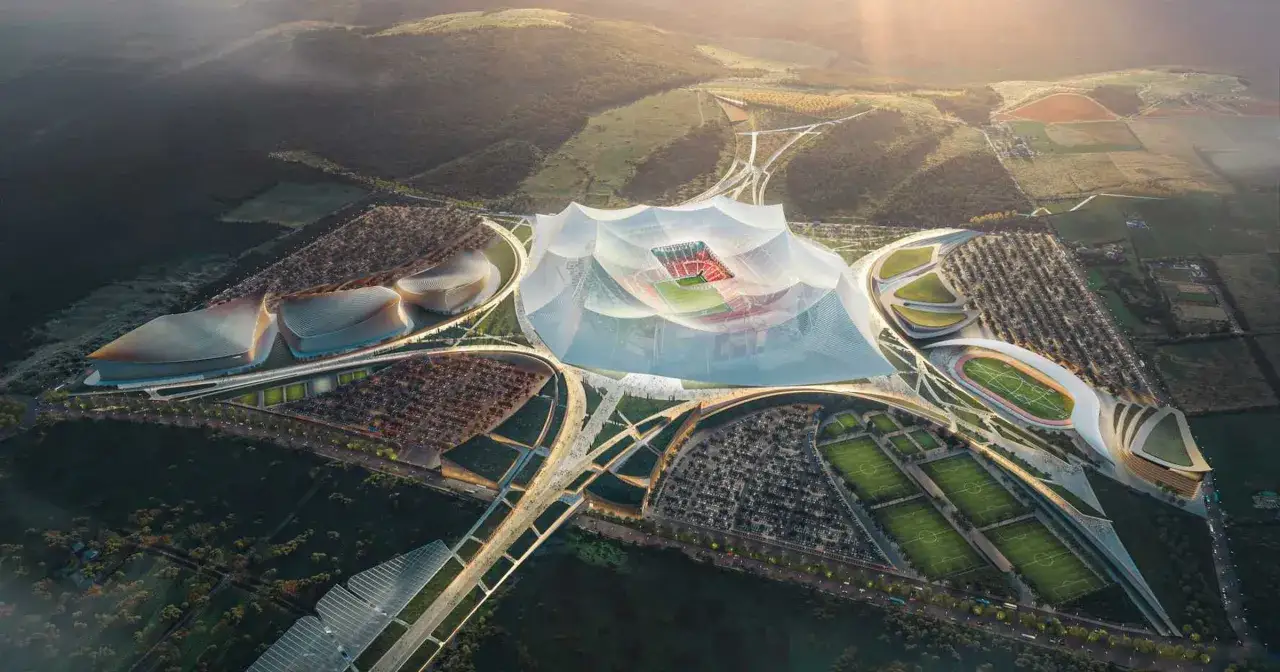 Futurystyczny kompleks sportowy z boiskiem i trybunami, otoczony zielenią i nowoczesnymi budynkami. To wizja największego stadionu na świecie.