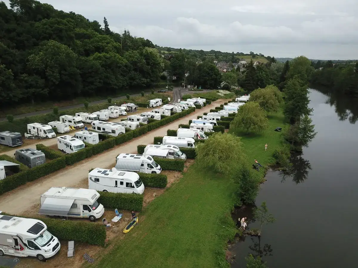 Un camping-car est gar&eacute; au bord d'une rivi&egrave;re, offrant un endroit id&eacute;al pour dormir en camping-car.