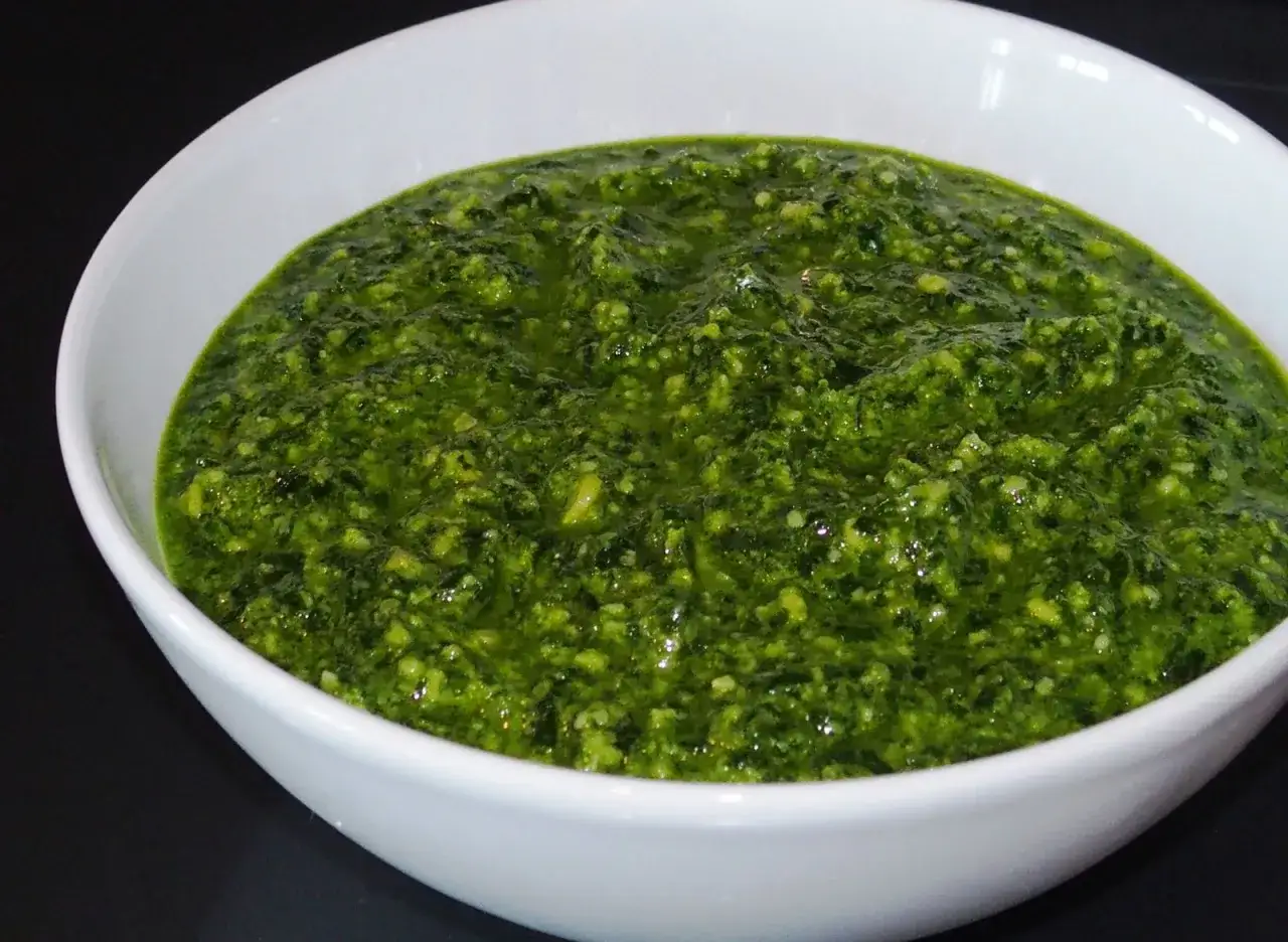 Un bol blanc rempli de pesto ail des ours, d'une belle couleur verte vibrante, pr&ecirc;t &agrave; &ecirc;tre d&eacute;gust&eacute;.