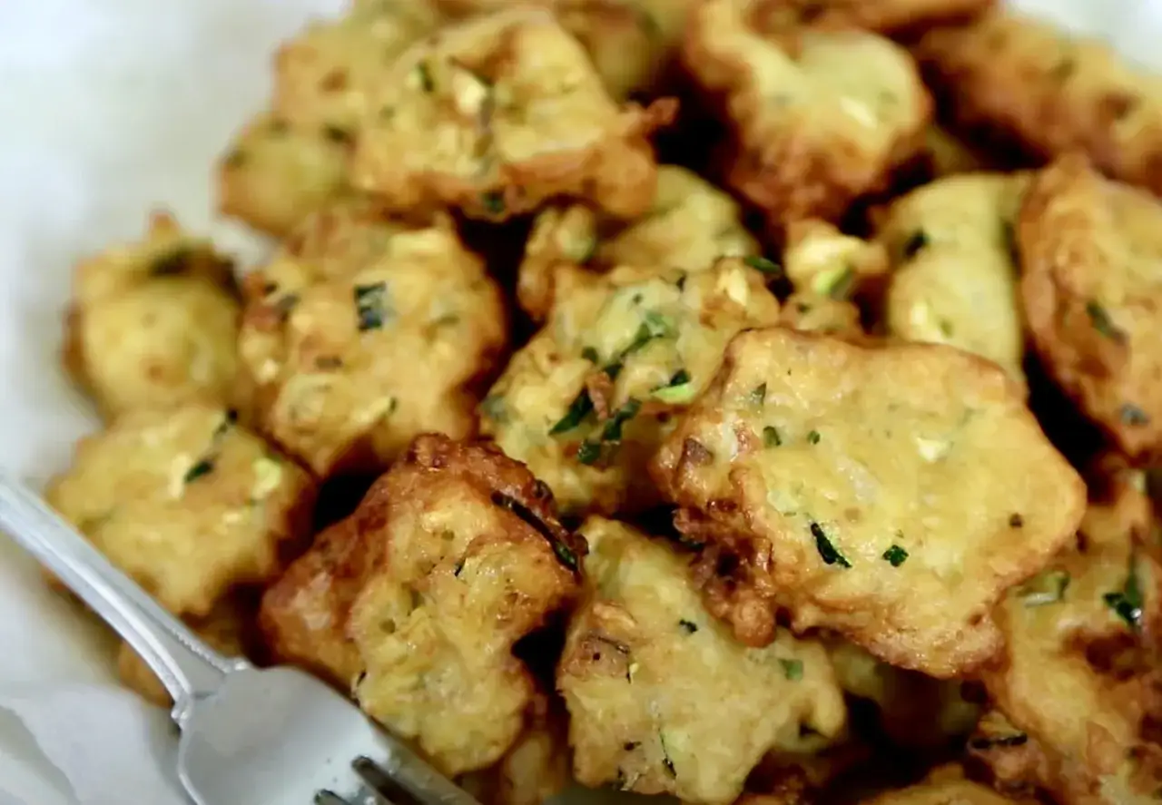 Une assiette de beignets de courgettes à l'italienne, dorés et croustillants, prêts à être dégustés.