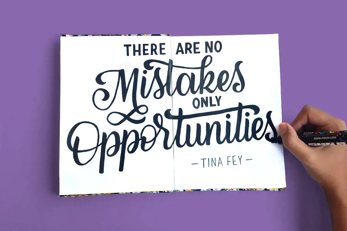 Manos creando un **curso de lettering gratis** con la frase 