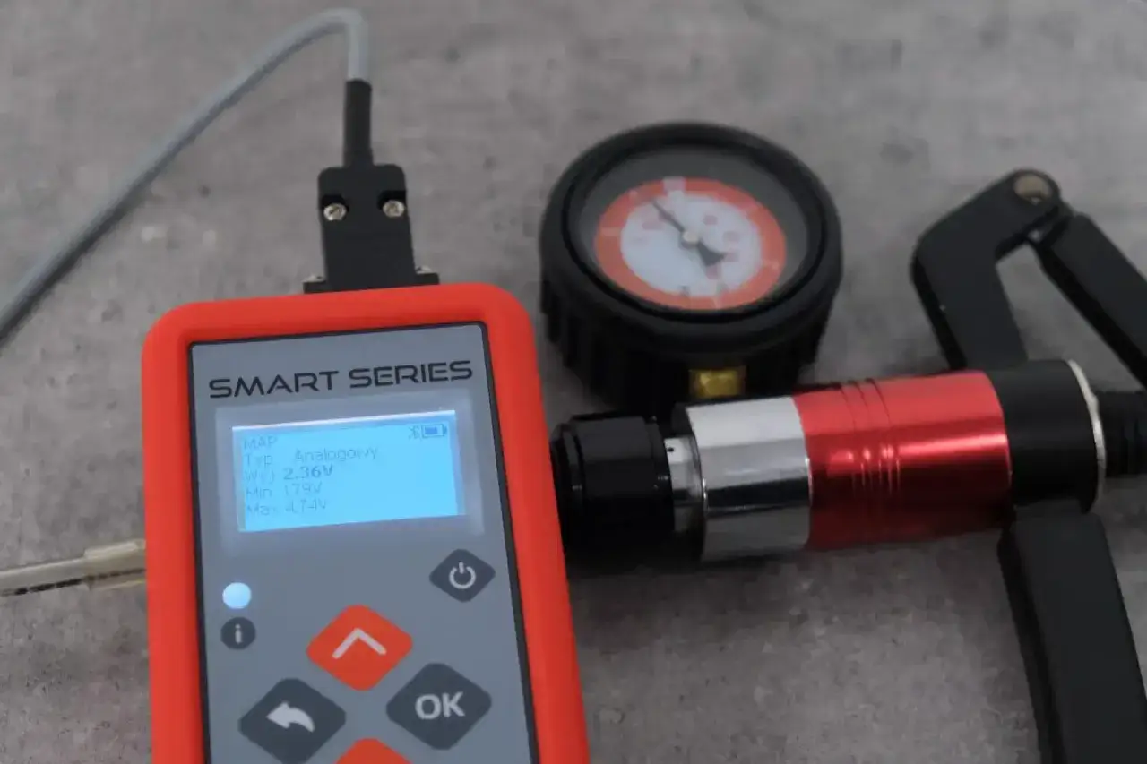 Narzędzia do diagnostyki: tester SMART SERIES, manometr i pompka. Pokazują, jak sprawdzić czujnik ciśnienia w kolektorze ssącym.