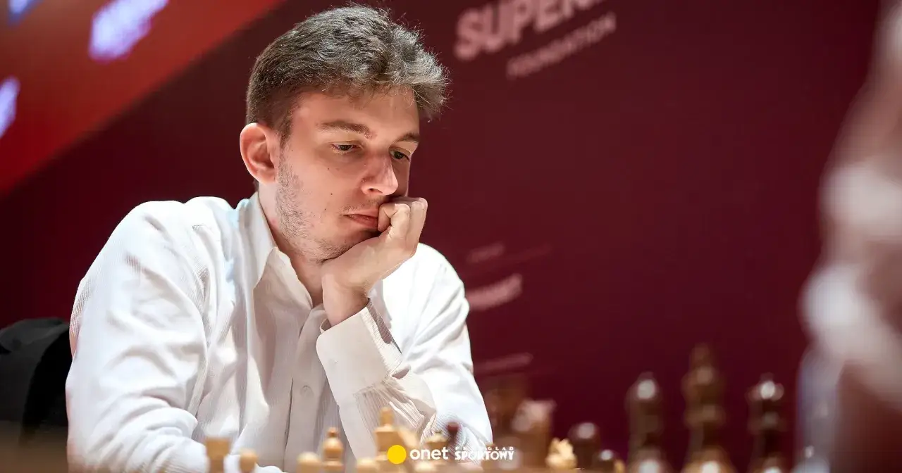 Młody **grandmaster** Jan Krzysztof Duda zamyślony nad szachownicą.