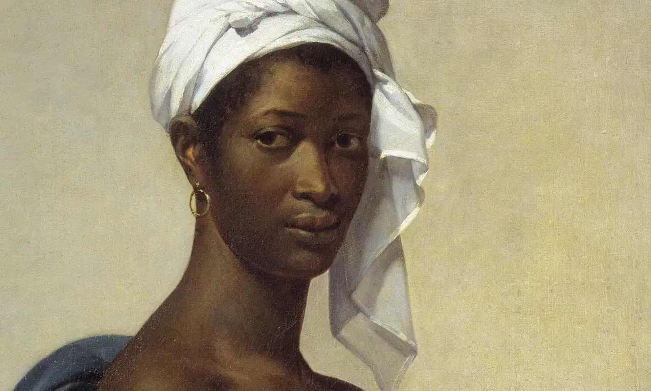 A striking portrait of Madeleine, her gaze direct, a white turban framing her face, and a gold hoop earring adorning her ear.