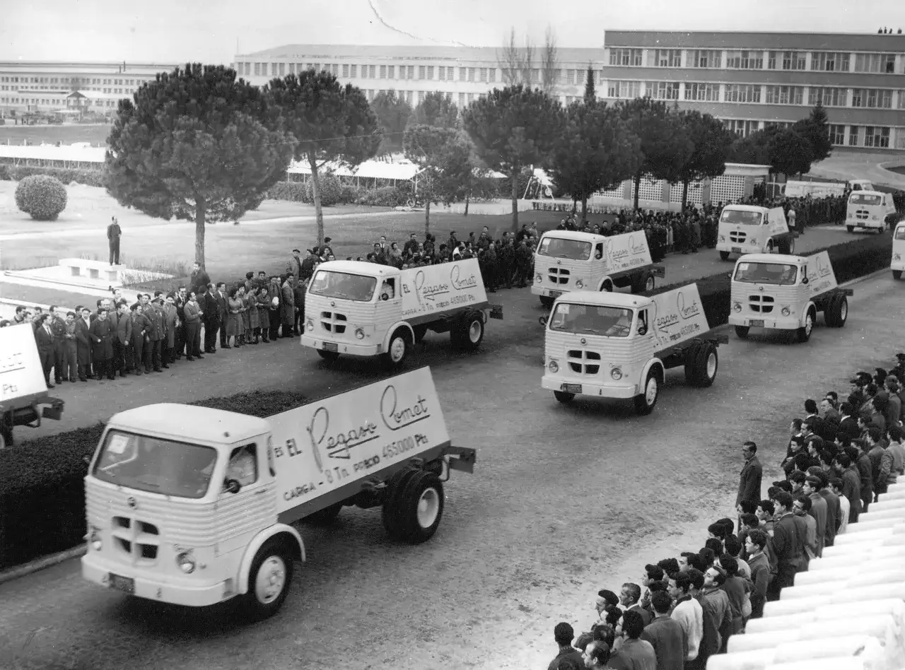 Une parade de camions Pegaso Comet espagnols d&eacute;file devant une foule.