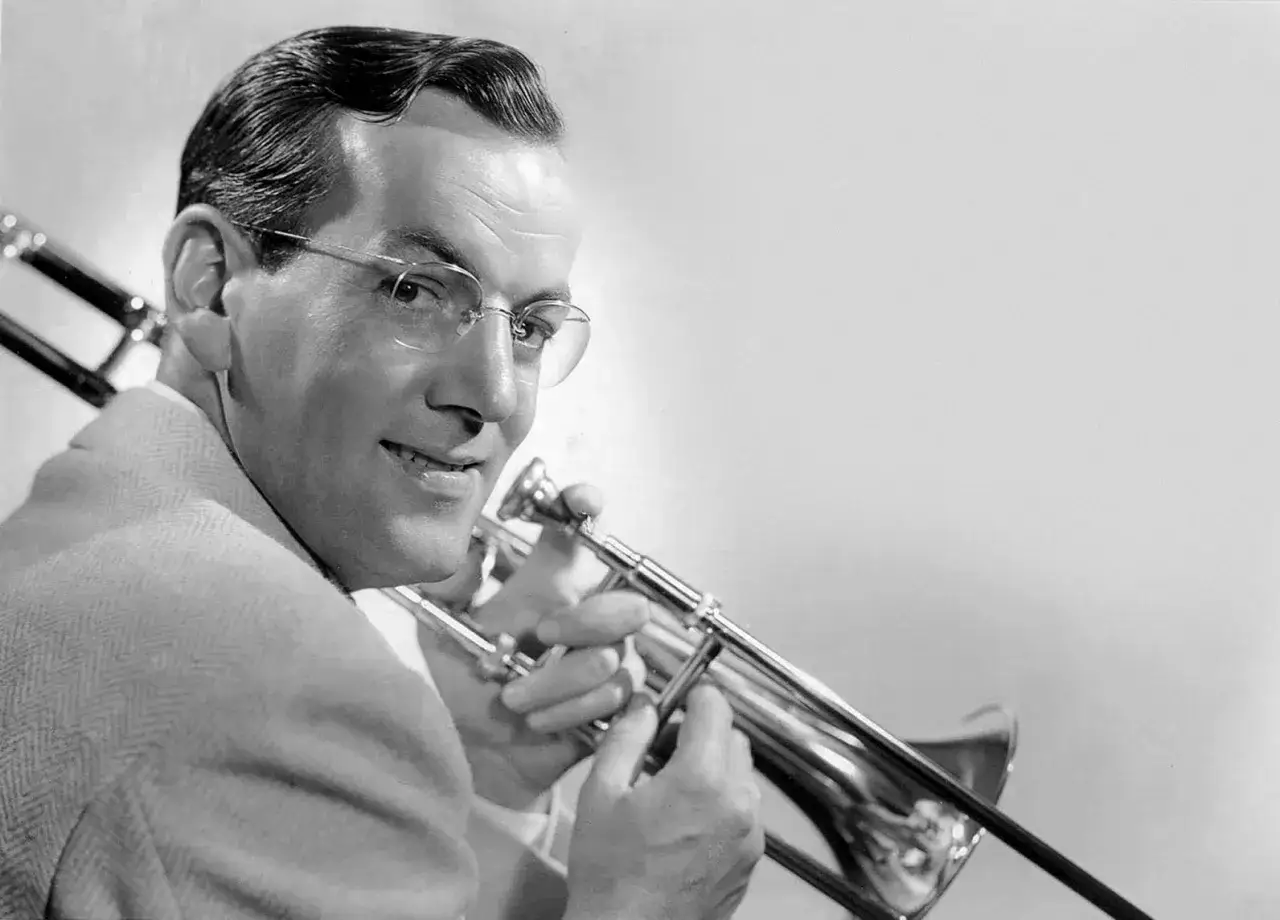 Músico con gafas tocando trombón, evocando la era dorada de las big bands famosas.