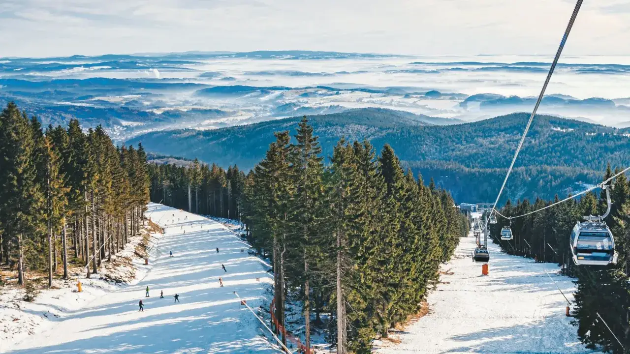 Skifahrer genießen die Pisten in Tschechien, während Gondeln über den verschneiten Hängen schweben.