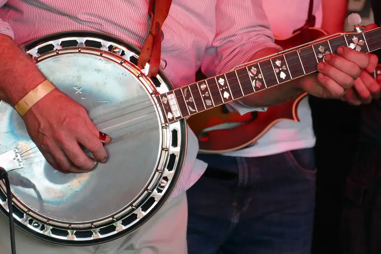 Ein Mann spielt ein Banjo, ein Saiteninstrument mit einem runden Korpus und einem langen Hals.