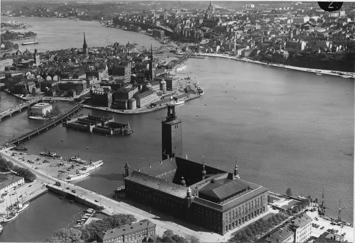 Vy &ouml;ver Stockholm med Stadshuset, en imponerande skyskrapa, som dominerar bilden vid vattnet.
