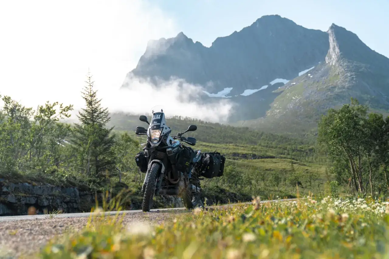Motocykl turystyczny gotowy na przygodę. W tle majestatyczne góry i mgły, idealne miejsce na tankowanie i dalszą podróż. Paliwo w Norwegii to klucz do odkrywania tych krajobrazów.