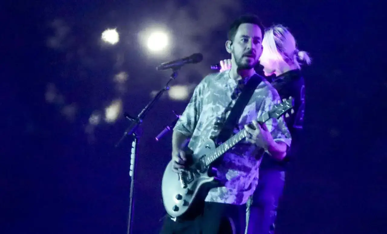 Mike Shinoda z Linkin Park gra na gitarze podczas koncertu w Polsce.