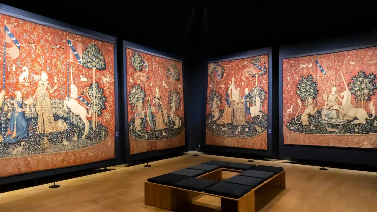 Vier Wandteppiche mit Einh&ouml;rnern und Damen im **Cluny Museum**. Ein moderner Sitzbereich l&auml;dt zum Betrachten der detailreichen Szenen ein.