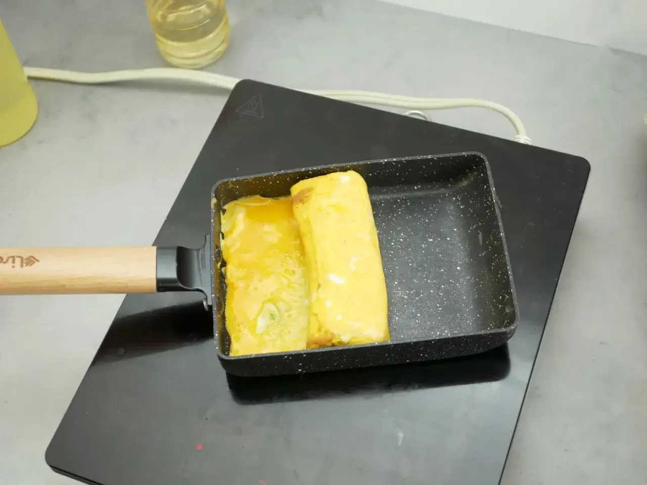 Deux rouleaux d'oeuf tamago dor&eacute;s et moelleux dans une po&ecirc;le rectangulaire, pr&ecirc;ts &agrave; &ecirc;tre d&eacute;gust&eacute;s.