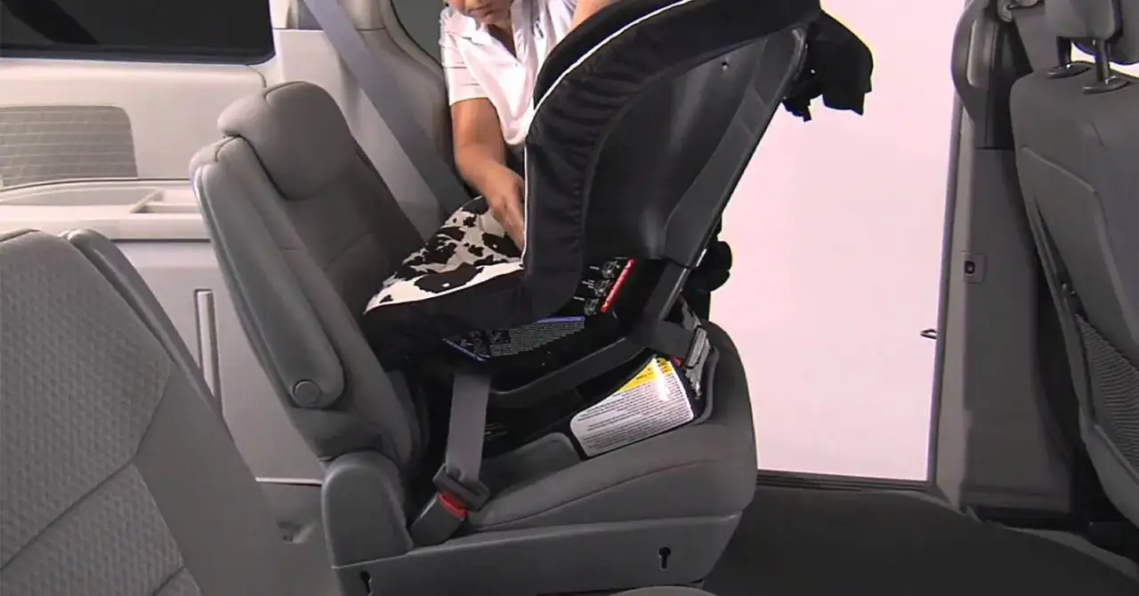 Persona ajustando el sistema sujeción infantil silla coche.