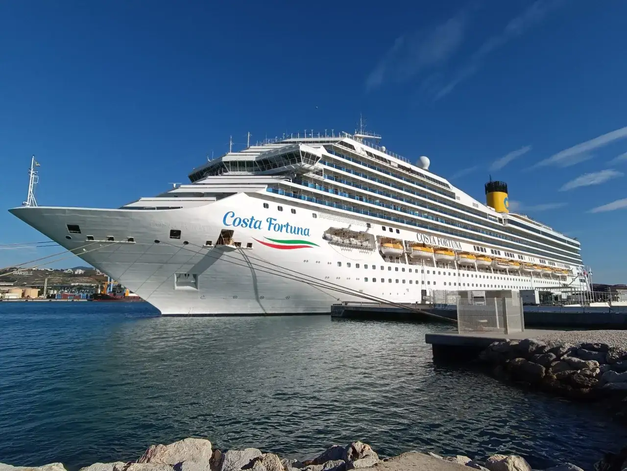 La Costa Fortuna, nave costruita nel 2007, attracca in porto sotto un cielo azzurro.