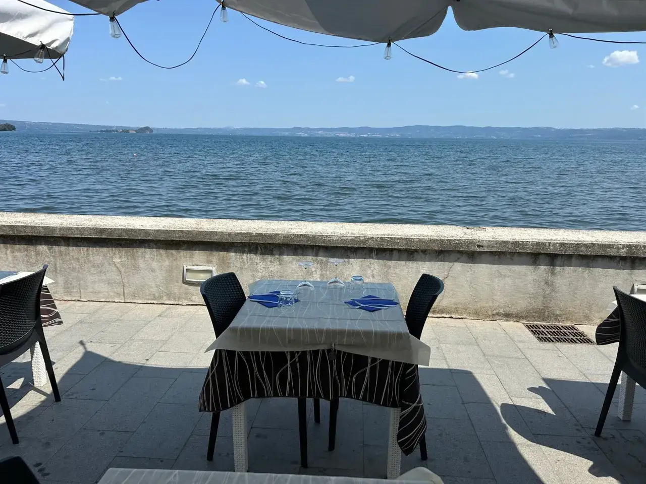 Tavolo apparecchiato con vista sul lago, ideale per gustare i **Bolsena ristoranti**.