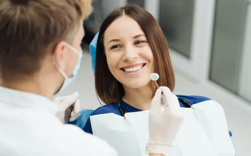 kobieta uśmiechnięta u dentysty, empatyczny dentysta