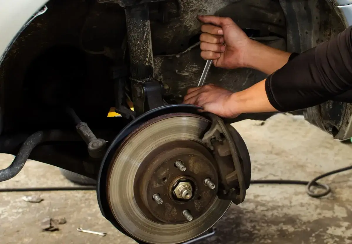 Mechanik używa klucza do pracy przy zacisku hamulcowym, co może być częścią procesu jak odpowietrzyć pompę ABS.