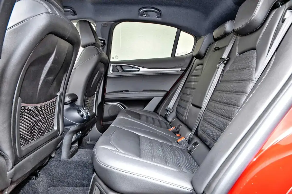 Wnętrze Alfa Romeo Stelvio. Skórzane fotele, kieszenie w oparciach, nawiewy. Wiele osób chwali komfort, co potwierdzają alfa romeo stelvio opinie.
