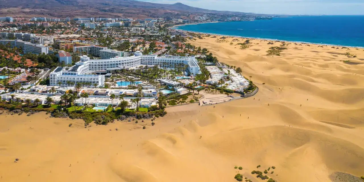Das Riu Palace Maspalomas liegt eingebettet in die Dünenlandschaft, mit Blick auf das Meer und die Stadt.