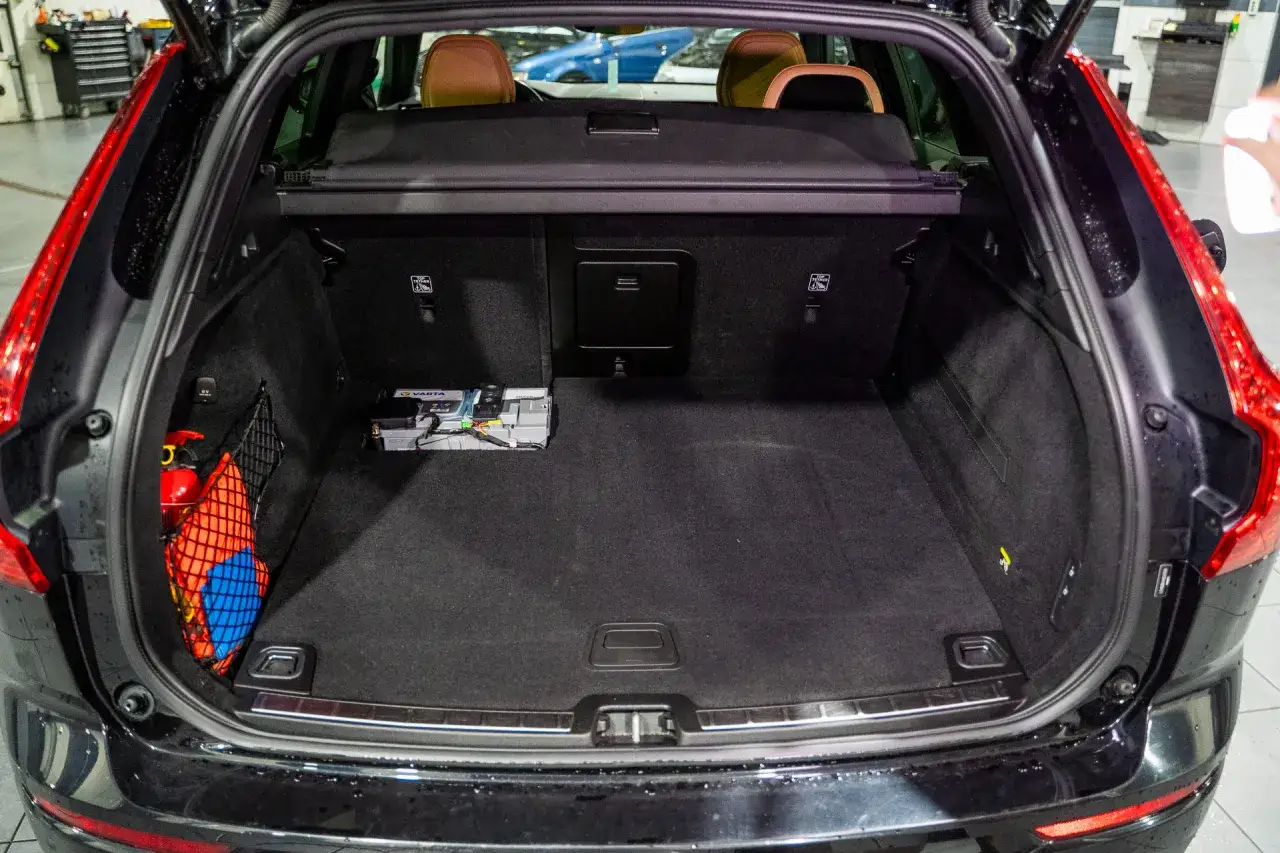 W Volvo XC60 akumulator znajduje się w bagażniku, po lewej stronie. Obok niego widoczna jest gaśnica.