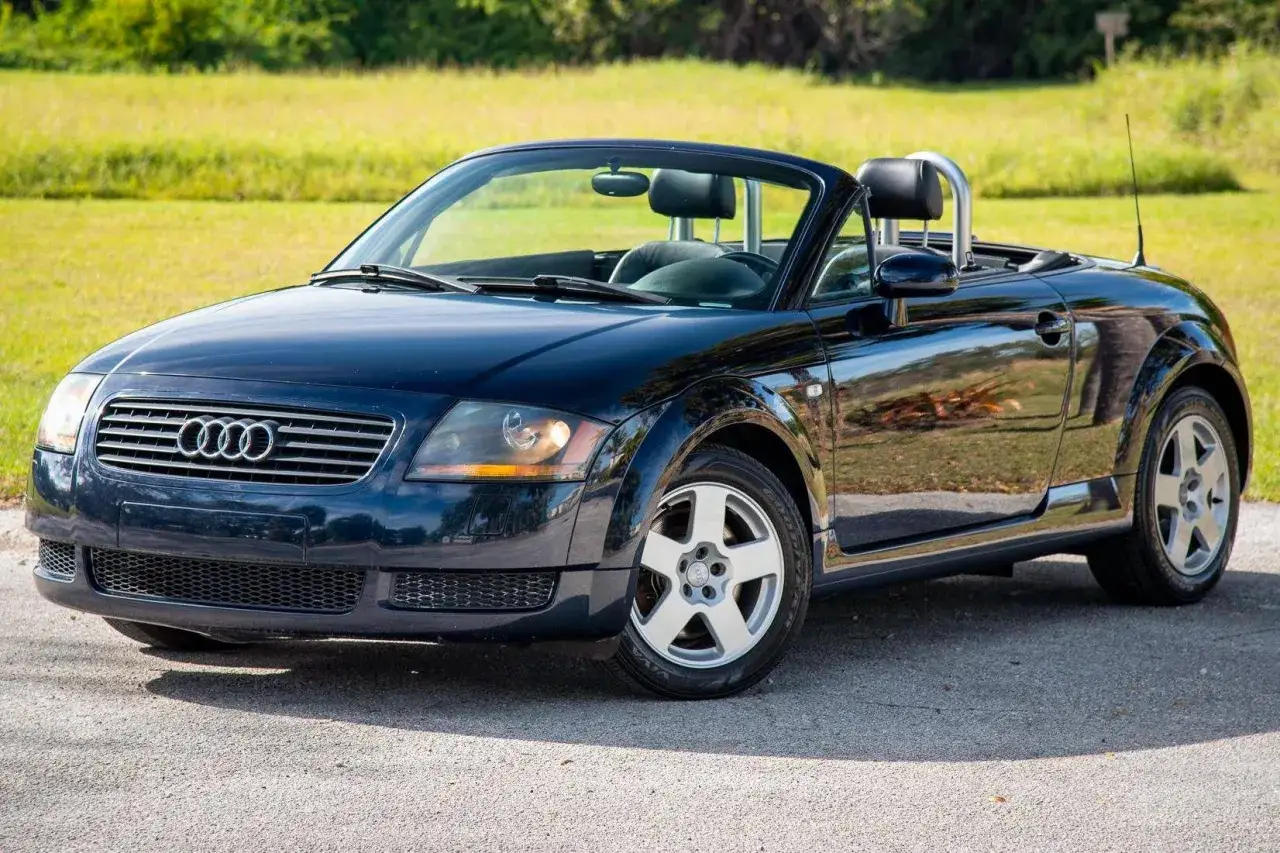 Dunkelblauer Audi TT Roadster von 2002 mit offenem Verdeck, bereit f&uuml;r eine Spritztour auf sonnigen Stra&szlig;en.