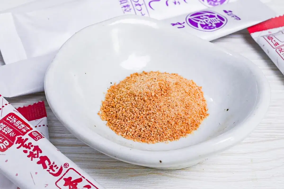 A small pile of dashi powder sits in a white dish, ready to be mixed with water. The dashi powder to water ratio is key for perfect broth.