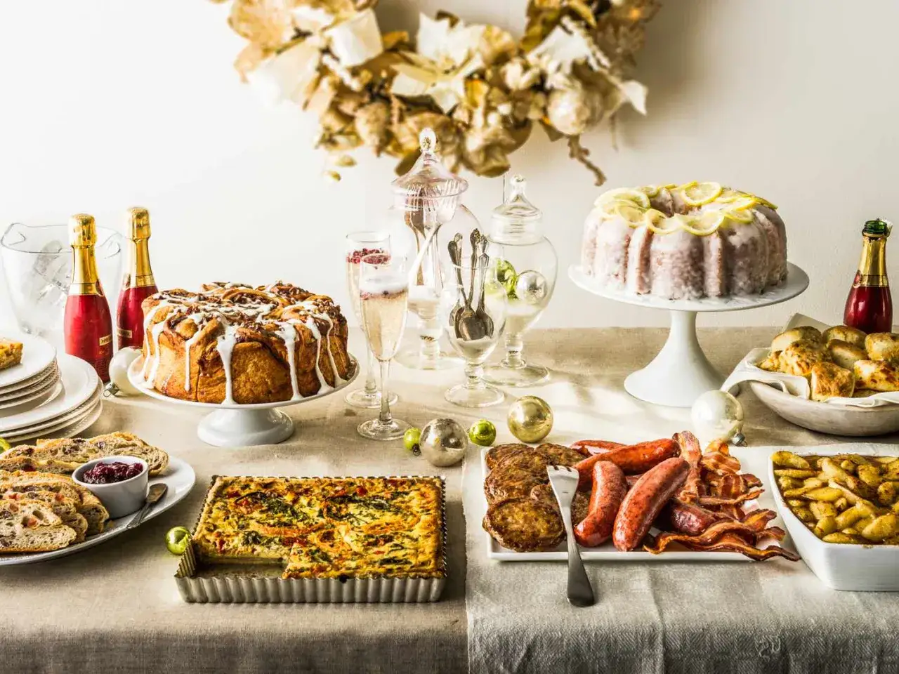 Festliches Brunch Buffet mit Kuchen, Quiche, Würstchen, Speck und Sekt.