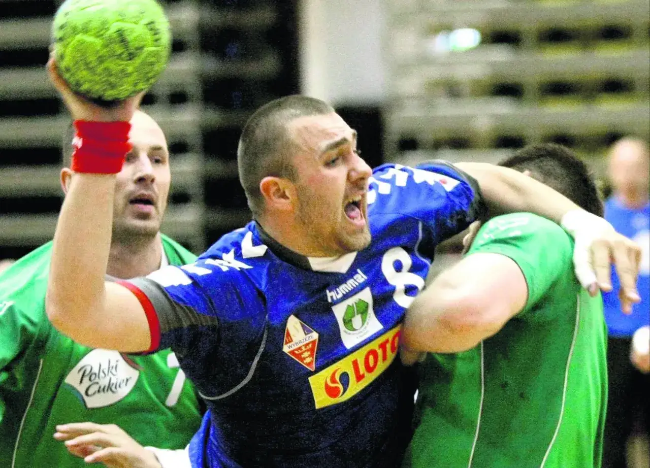 Michał Piwowarczyk w akcji, rzuca piłką do bramki.
