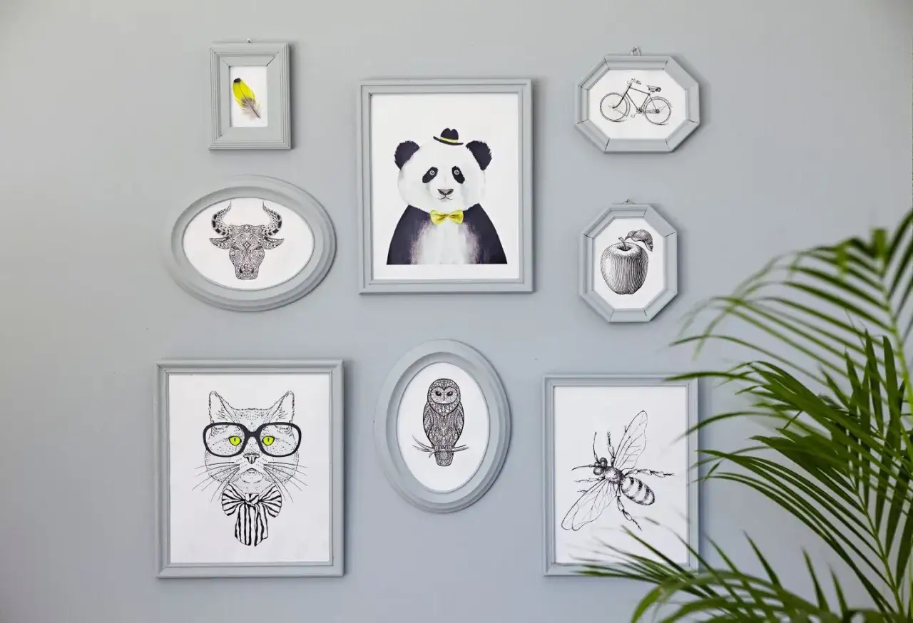 Sju gr&aring;a ramar med djur och f&ouml;rem&aring;l. En panda med fluga, en katt med glas&ouml;gon, en tjur, en uggla, en bi, ett &auml;pple och en cykel. N&aring;gon har valt att m&aring;la ramar f&ouml;r att skapa en fin v&auml;ggdekoration.