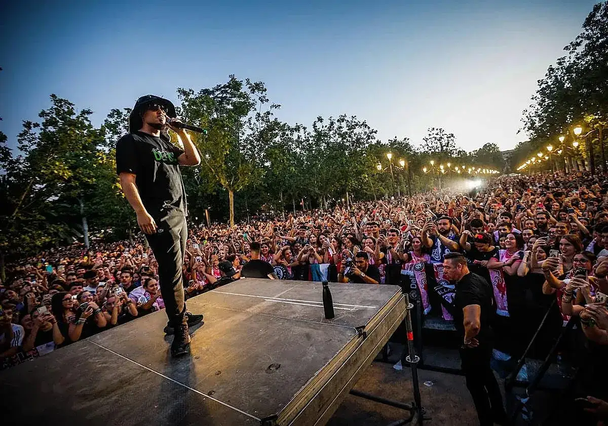 Un artista canta ante una multitud en un concierto al aire libre. La **dellafuente biografia** se escribe con cada actuación.