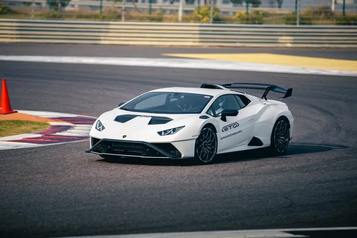 Biały Lamborghini Huracan STO na torze wyścigowym, gotowy do akcji.