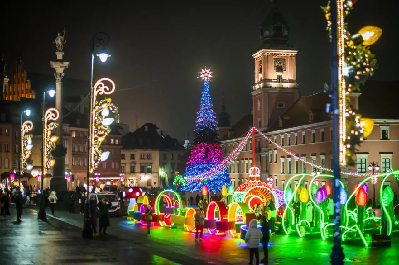 Magiczny jarmark świąteczny Warszawa nocą. Kolorowe iluminacje, choinka i tłumy ludzi tworzą niepowtarzalną atmosferę.