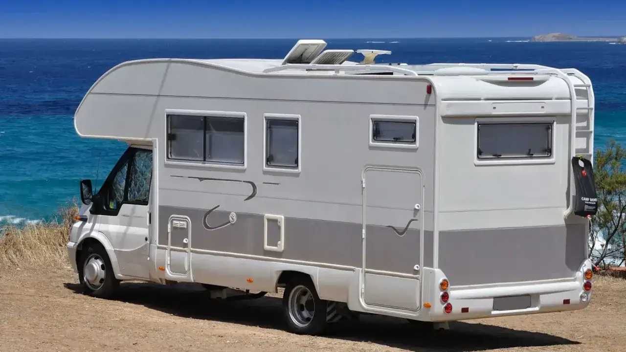 Camping-car blanc stationn&eacute; sur une aire de camping-car &agrave; Bormes-les-Mimosas, face &agrave; la mer bleue.