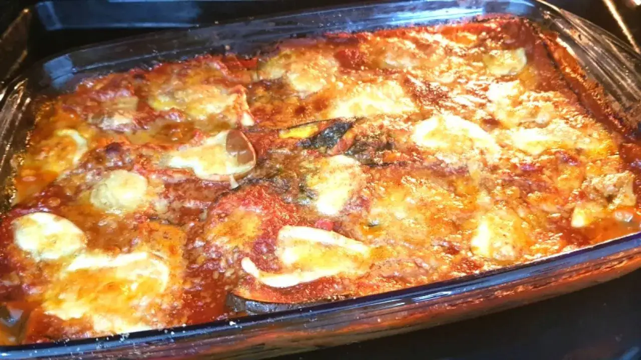 Parmigiana di melanzane non fritte appena sfornata, dorata e filante, pronta per essere gustata.
