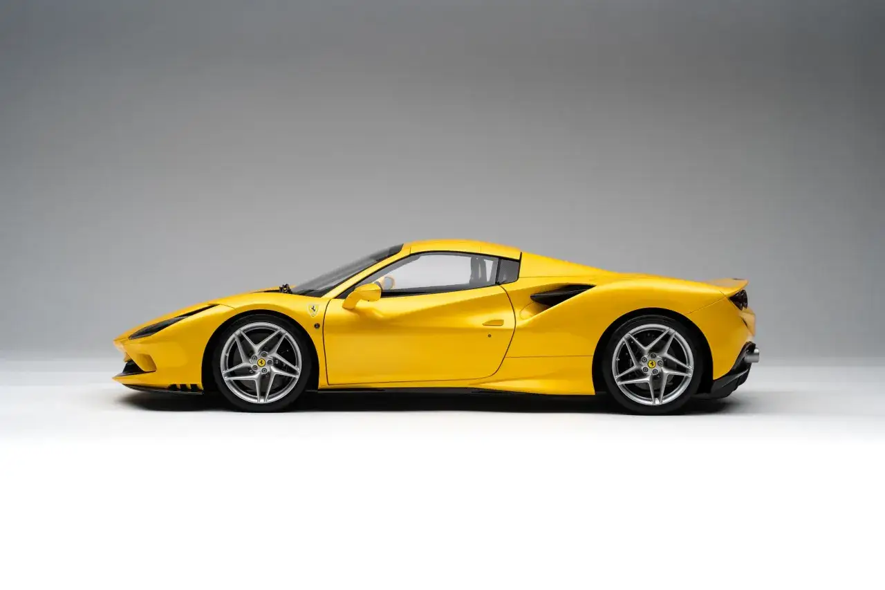 Żółte Ferrari F8, sportowy samochód o aerodynamicznej sylwetce, prezentuje się na jednolitym tle.