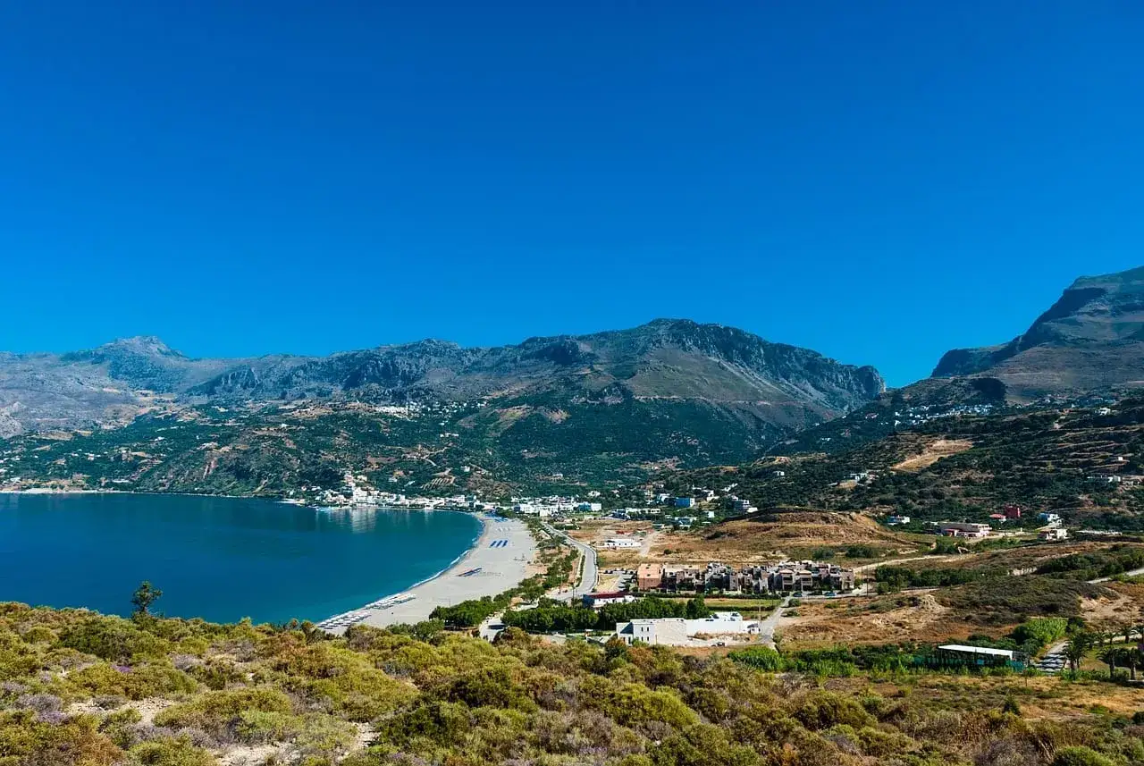 Piękna, słoneczna **kreta pogoda w kwietniu**. Błękitne morze, piaszczysta plaża i góry w tle. Idealne miejsce na wiosenny wypoczynek.