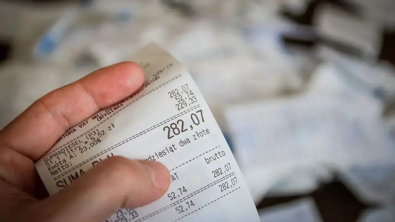 Dłoń trzyma paragon z zakupem paliwa. Kwota brutto to 282,07 zł. Czy to będzie zwrot bez paragonu?