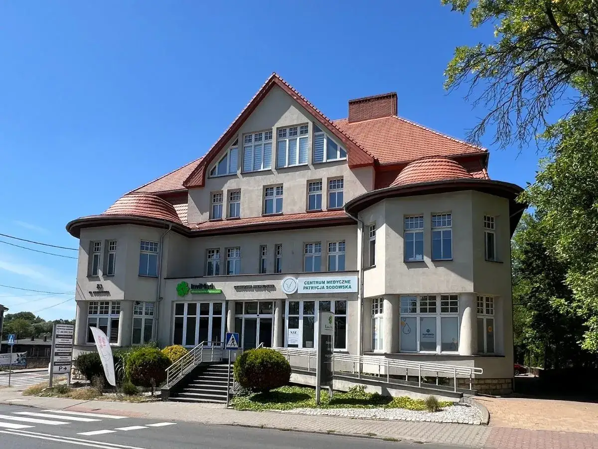 Elegancki budynek Centrum Medycznego Patrycja Sadowska w Katowicach z czerwonym dachem i zielonymi akcentami.