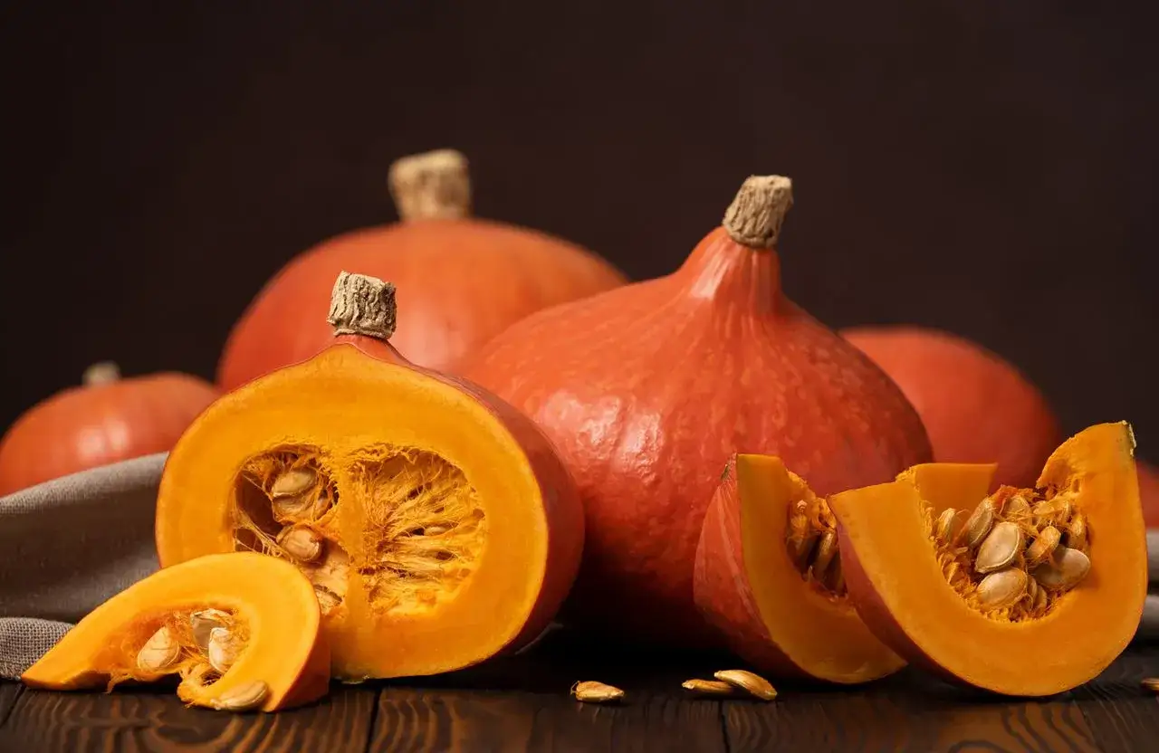 Des citrouilles enti&egrave;res et coup&eacute;es, r&eacute;v&eacute;lant leur chair orang&eacute;e et leurs graines. Un aper&ccedil;u de la culture potiron, pr&ecirc;te &agrave; &ecirc;tre transform&eacute;e en d&eacute;lices automnaux.