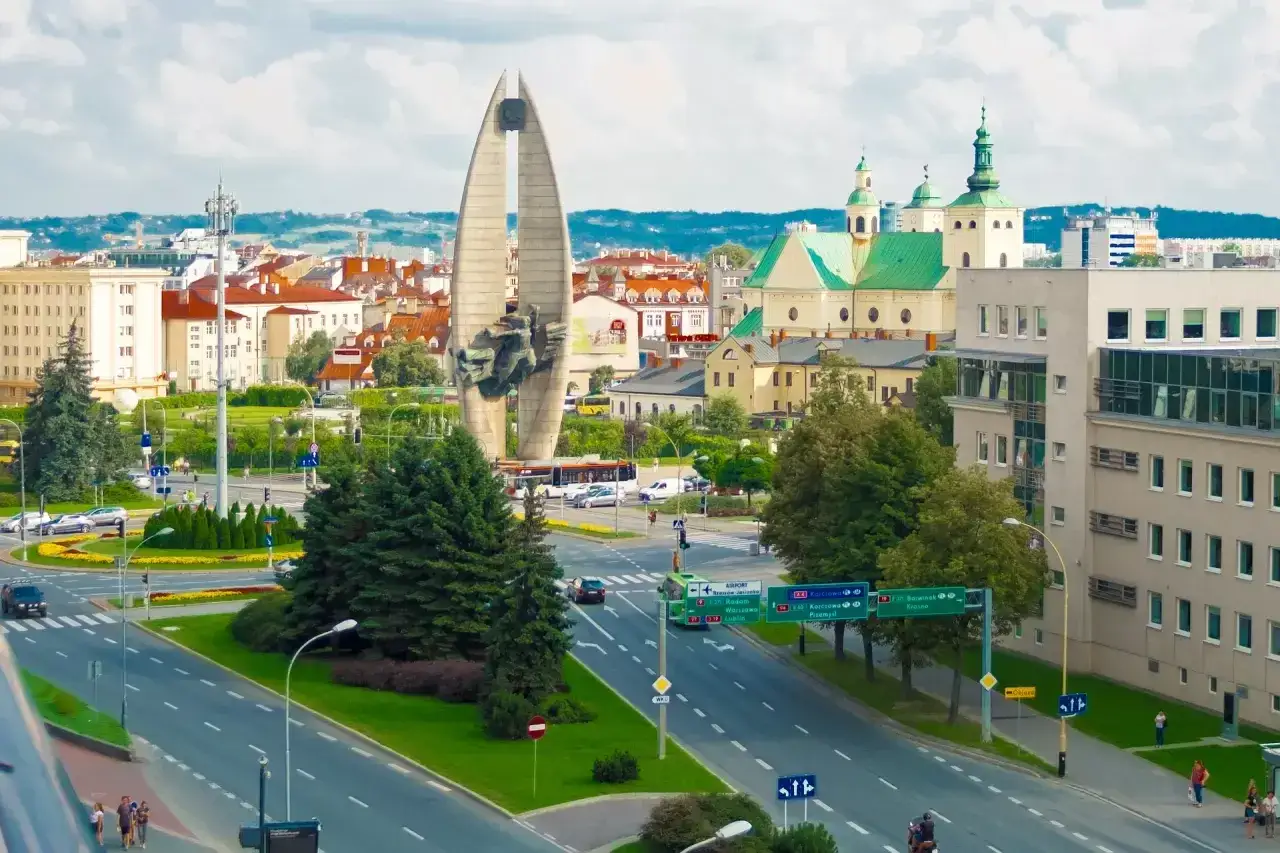 Widok na pomnik, kościół i ruchliwe skrzyżowanie w Rzeszowie.