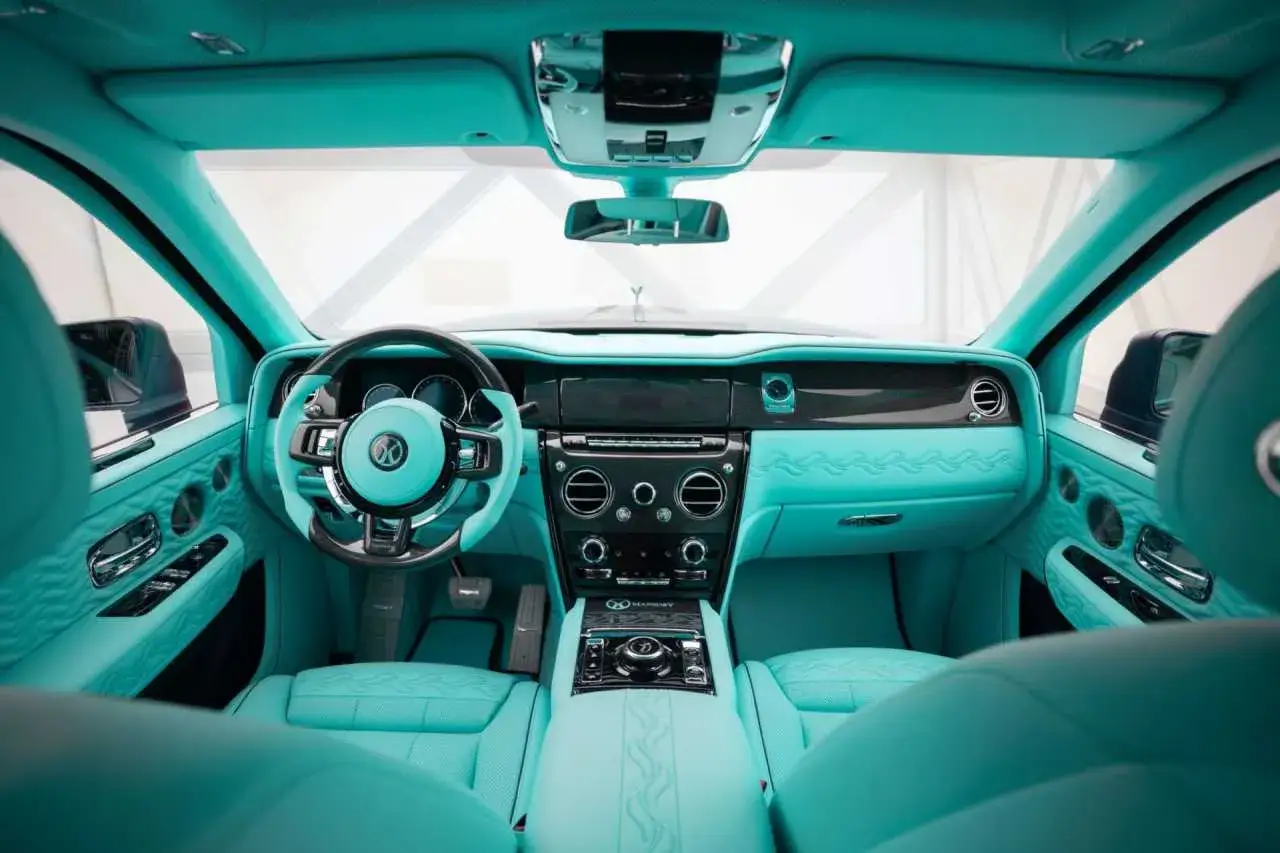 Wnętrze Rolls-Royce SUV w turkusowej skórze, z kierownicą i deską rozdzielczą w tym samym kolorze. Luksus i styl w każdym detalu.